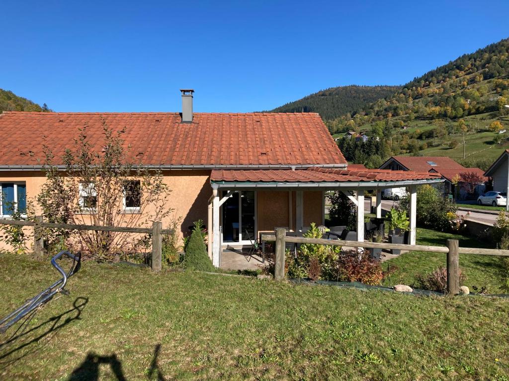 una casa con un tetto rosso in cima a un cortile di Gite Les Cimes a La Bresse