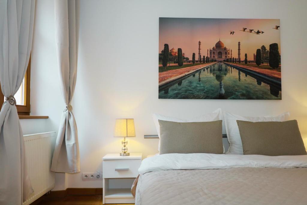 a bedroom with a bed with a painting on the wall at Charming apartment in the heart of Bratislava in Bratislava