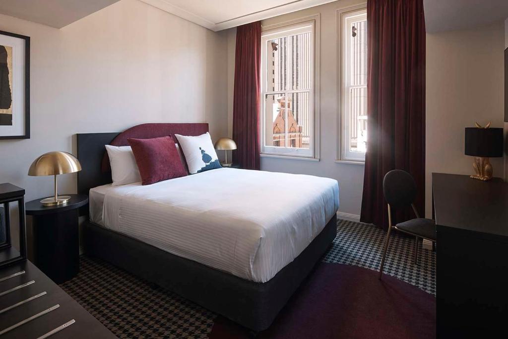 pokój hotelowy z łóżkiem i oknem w obiekcie The Capitol Hotel Sydney w mieście Sydney