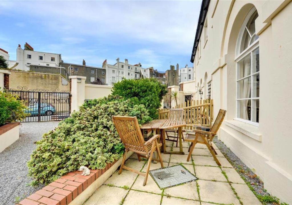 a patio with chairs and a table on a balcony at Kemp Town Mews in Brighton & Hove