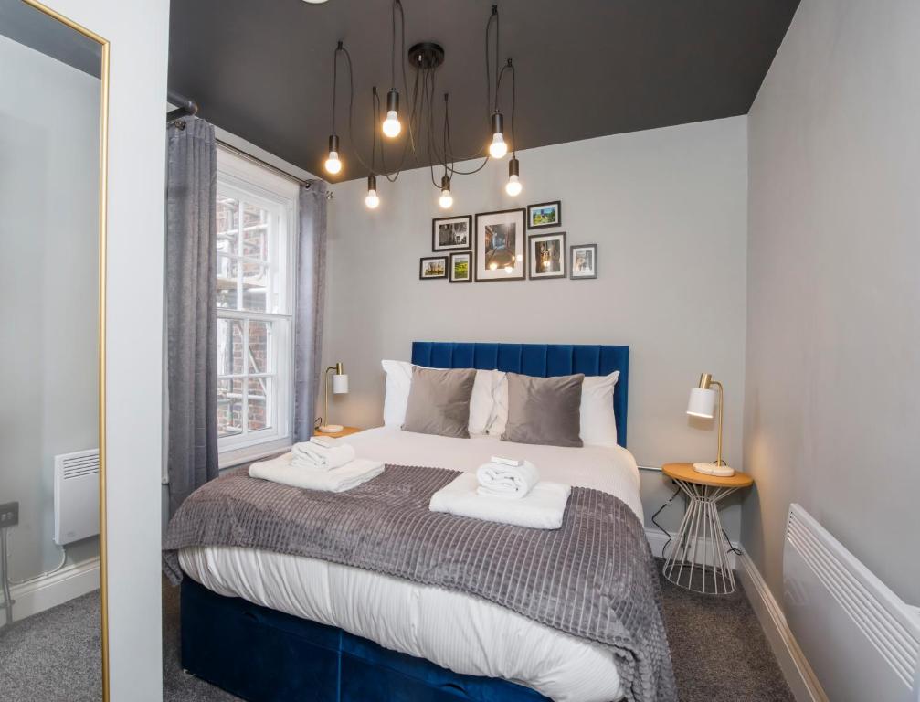 1 dormitorio con 1 cama grande y 2 toallas. en Bateman, modern City centre apartment sleeps 6 en York