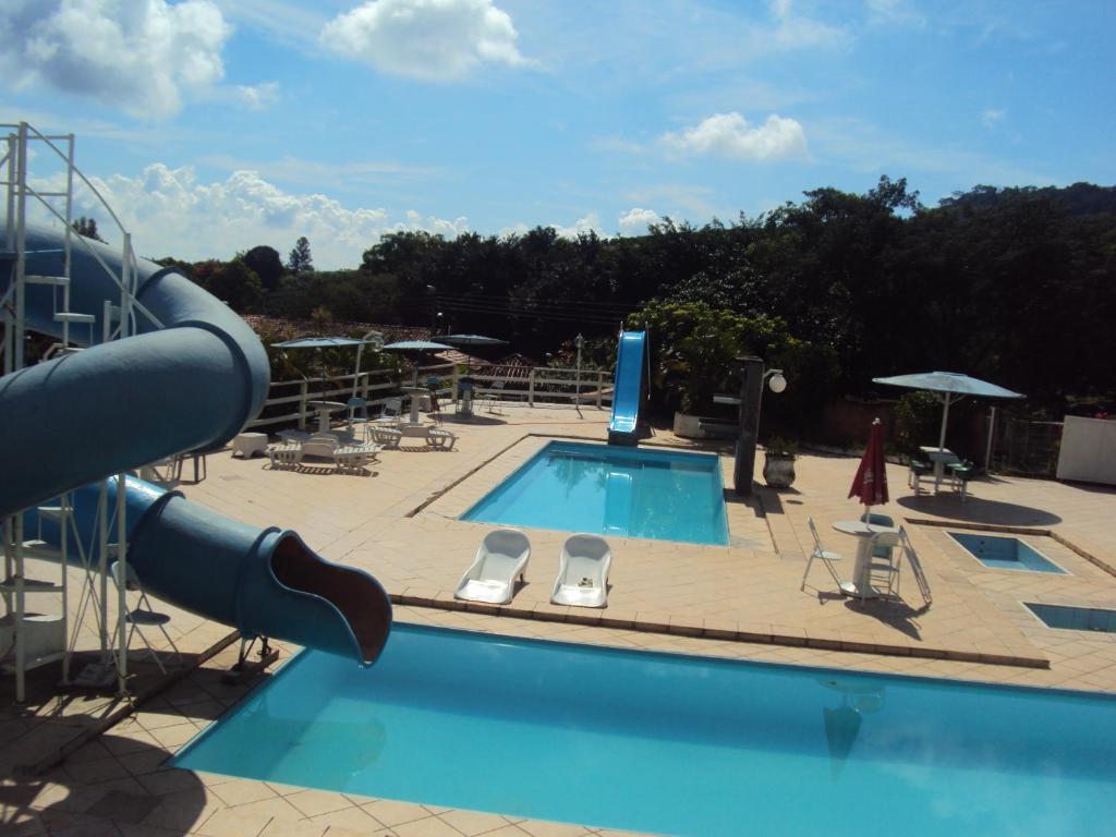 une grande piscine avec un toboggan dans l'établissement Pousada Sitio Bom Fim, à Serra Negra