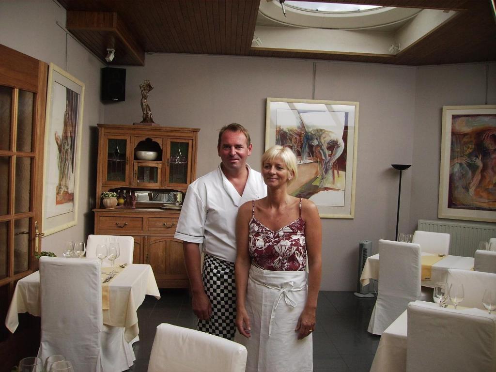 un homme et une femme debout dans une salle à manger dans l'établissement Hotel Hooghuys, à Hamont