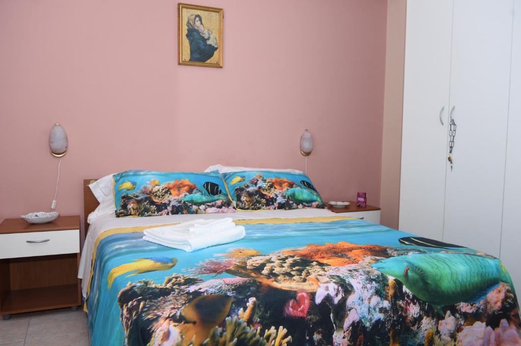 SiciliaEtnaMinio في ماسكالي: غرفة نوم مع سرير مع لحاف ملون