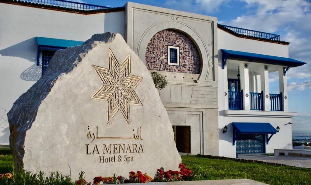 西迪布賽義德的住宿－La Menara Hotel & SPA，房屋前有标志的建筑物
