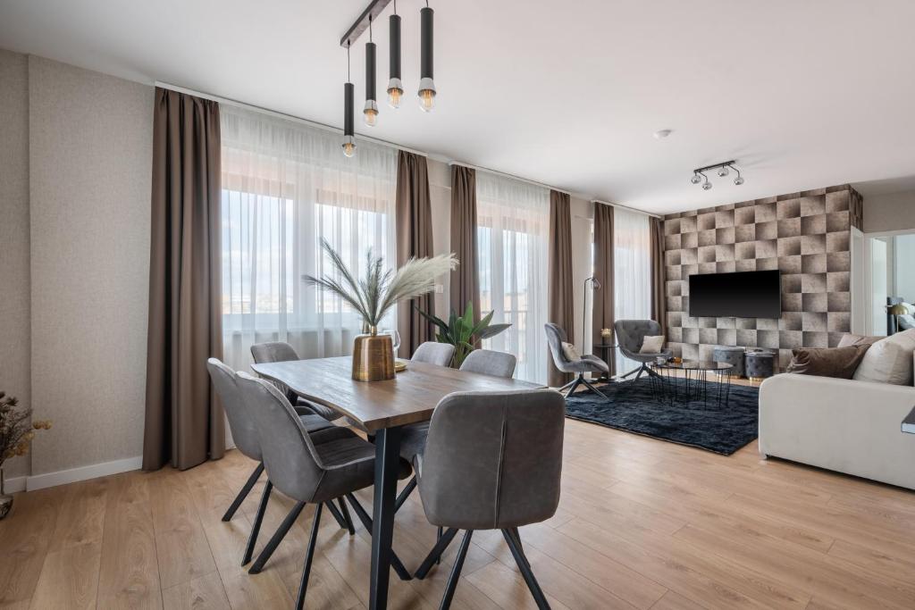 ein Esszimmer mit einem Tisch und Stühlen sowie ein Wohnzimmer in der Unterkunft The Rose Garden Apartments in Budapest