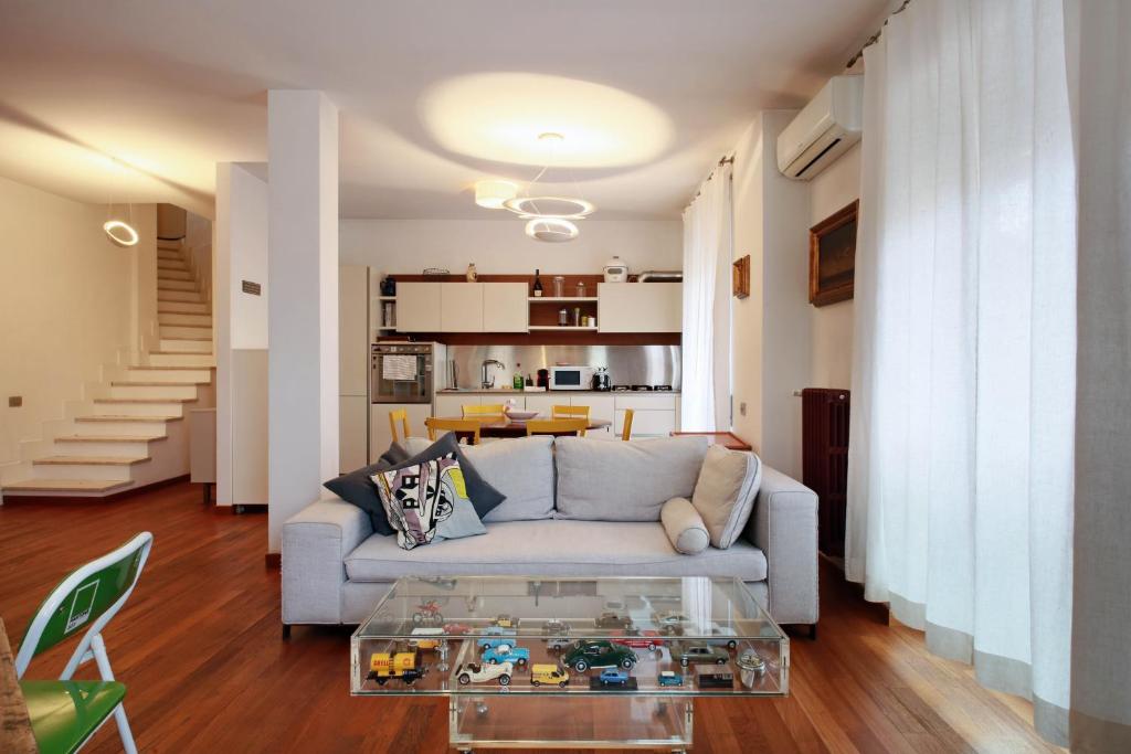 een woonkamer met een bank en een glazen tafel bij Appartamento Trastevere & Pascarella in Rome