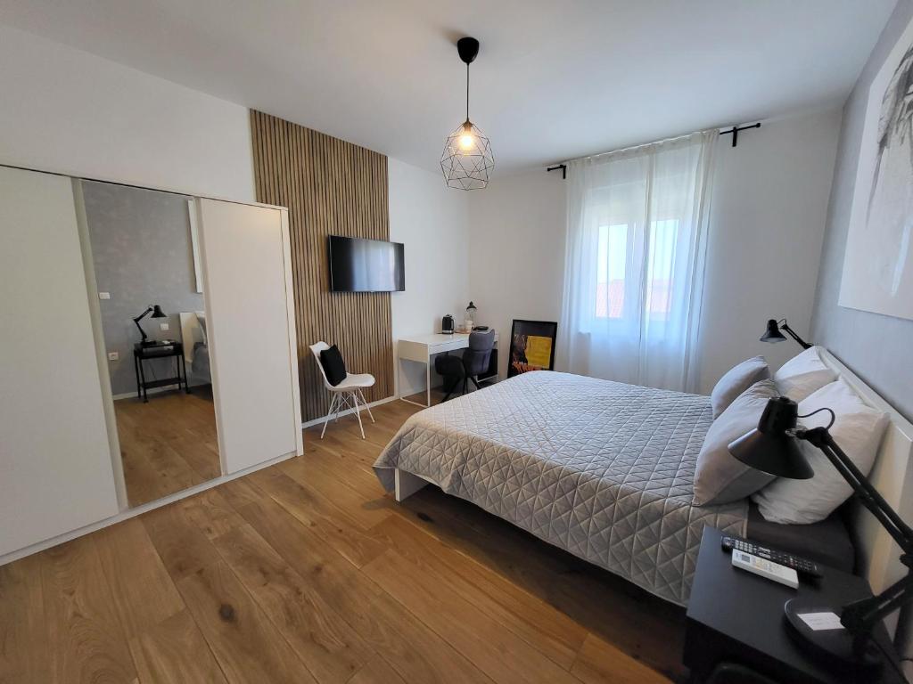 a bedroom with a bed and a desk and a television at Central rooms in Šibenik