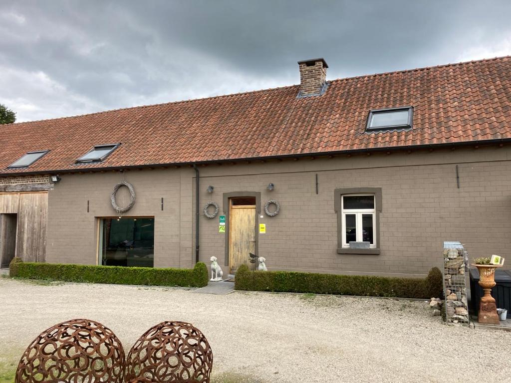 une maison avec un chien assis à l'extérieur dans l'établissement B&B Crijbohoeve, à Zutendaal