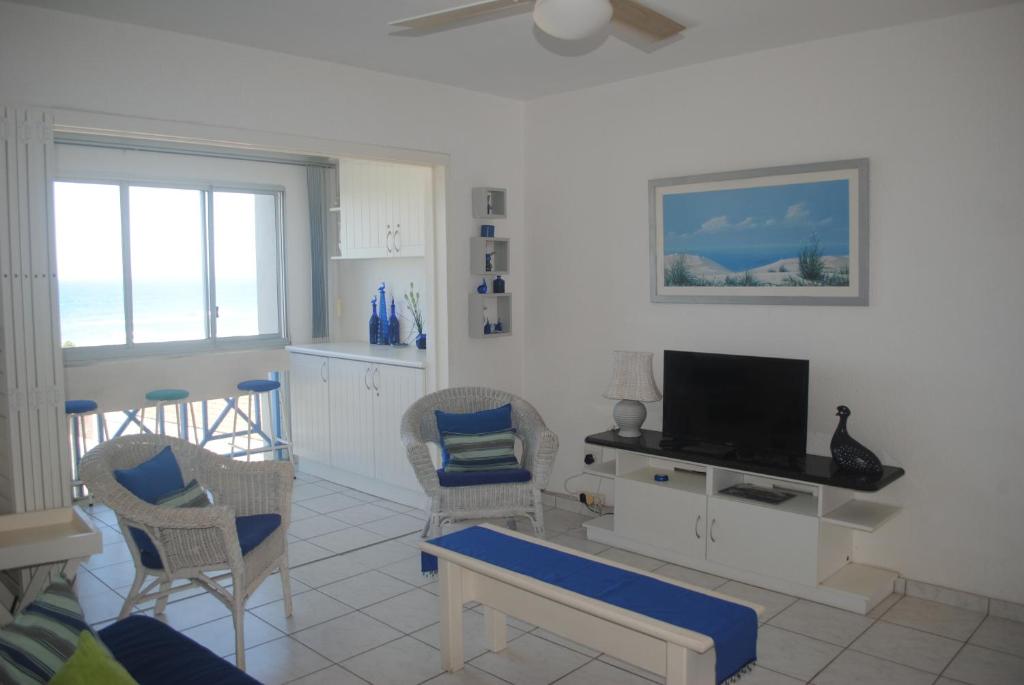 a living room with a tv and two chairs at 37 Key Largo in Kingsborough