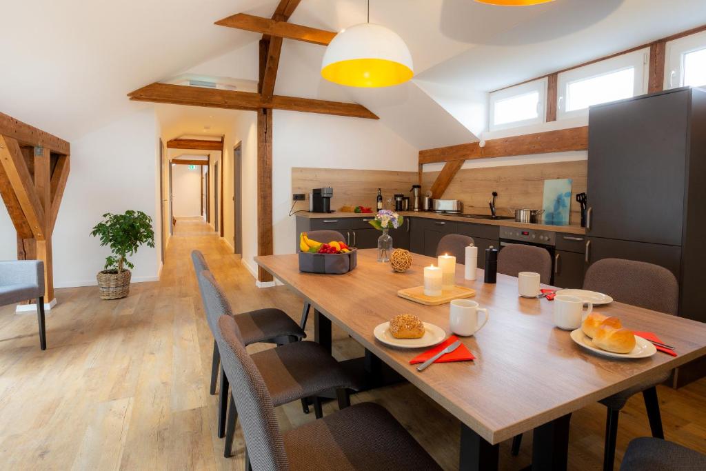聖安德里斯伯格的住宿－Lieblingsquartier St. Andreasberg，厨房以及带木桌和椅子的用餐室。