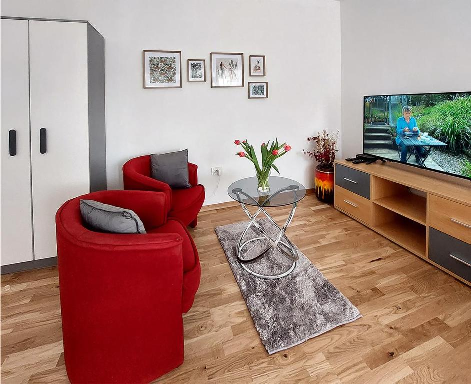 a living room with a red chair and a tv at Apartment Oliva in Knin