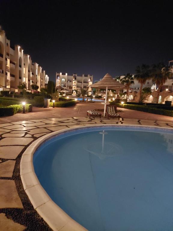 a swimming pool at night with buildings in the background at Two Bedroom at Sunny Lakes Resort in Sharm El Sheikh