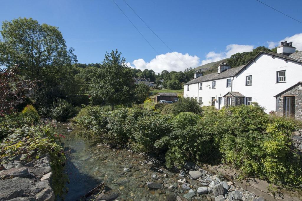 a river in front of a white house at No 3 The Forge Coniston in Coniston