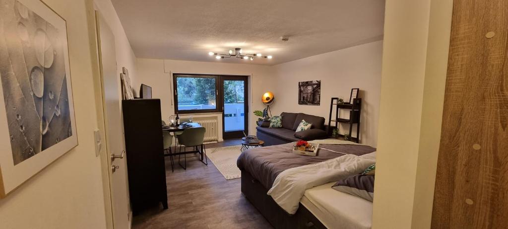Cette chambre comprend un lit, un canapé et une table. dans l'établissement Tolle Wohnung im Industrial Style mit Parkplatz, à Aschaffenbourg
