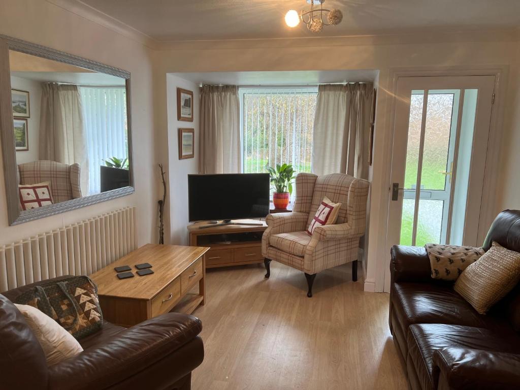 a living room with a couch and a tv at Luxury Super King Bed in Stratford-upon-Avon