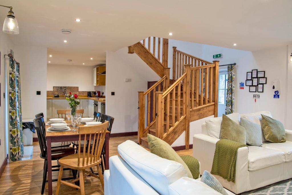 a living room with a white couch and a table at Stainsborough Hall Holiday Cottages in Wirksworth