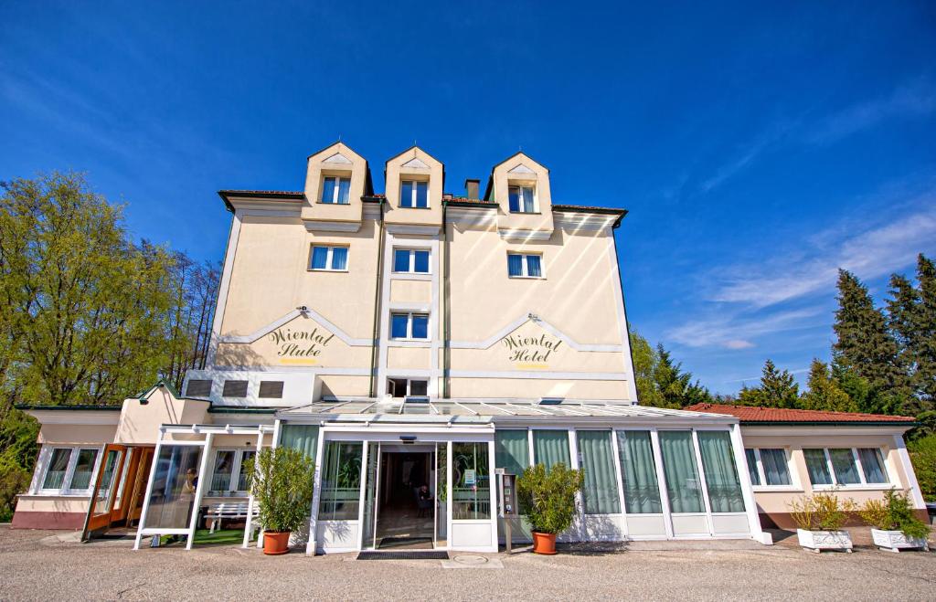 duży biały budynek z oknami i drzwiami w obiekcie Hotel Wiental w mieście Pressbaum
