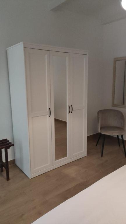 a white cabinet in a room with a chair at Lovin Puglia Vacation in Bari