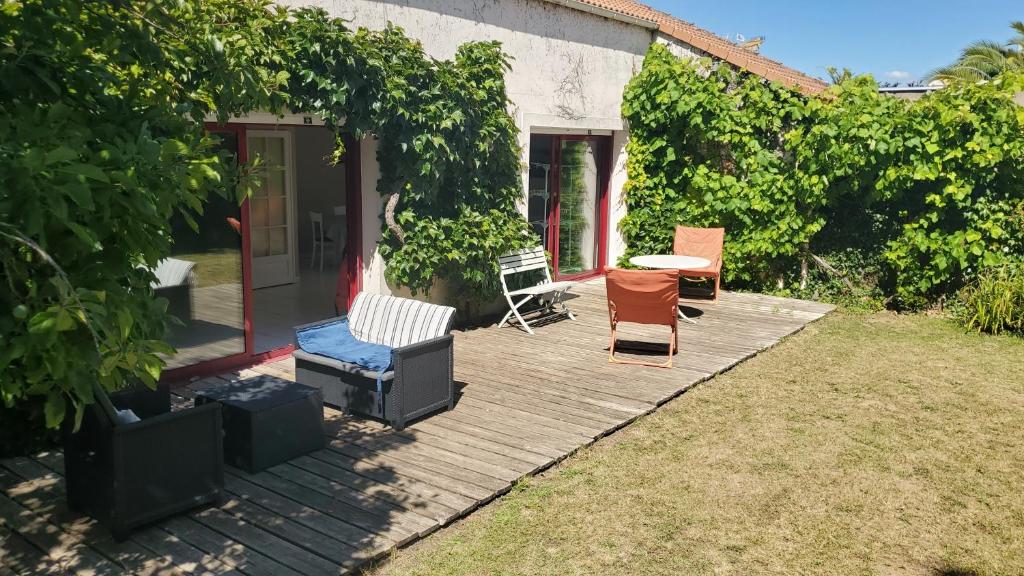 une terrasse en bois avec des chaises et une table. dans l'établissement Pornic - maison familiale 8p - plage & port à pied, à Pornic
