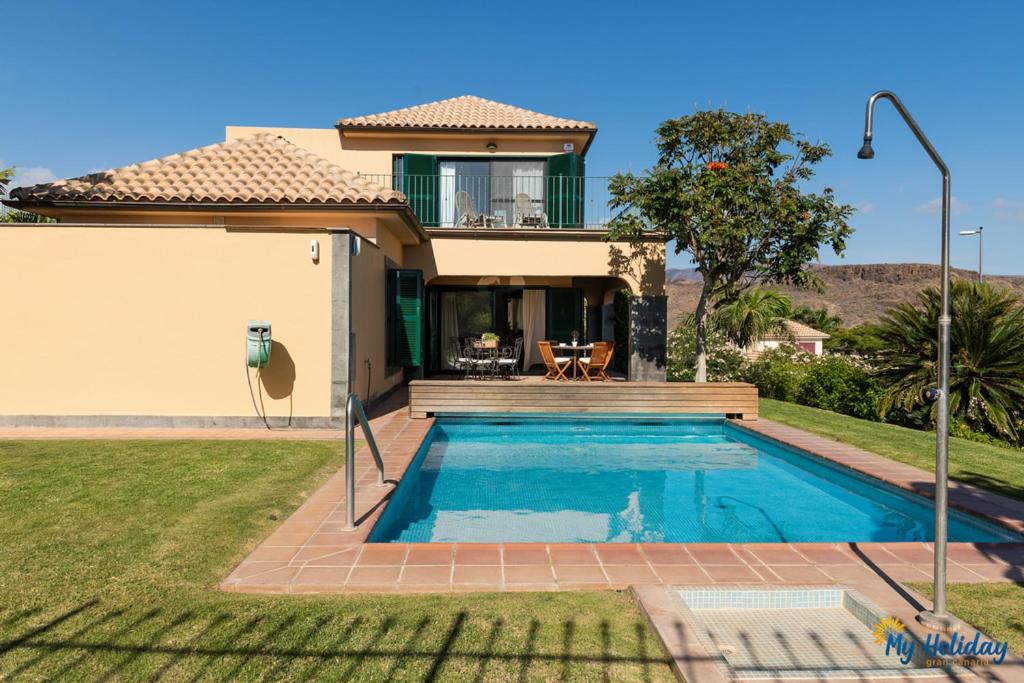 een villa met een zwembad voor een huis bij Villa Monte Leon in Maspalomas
