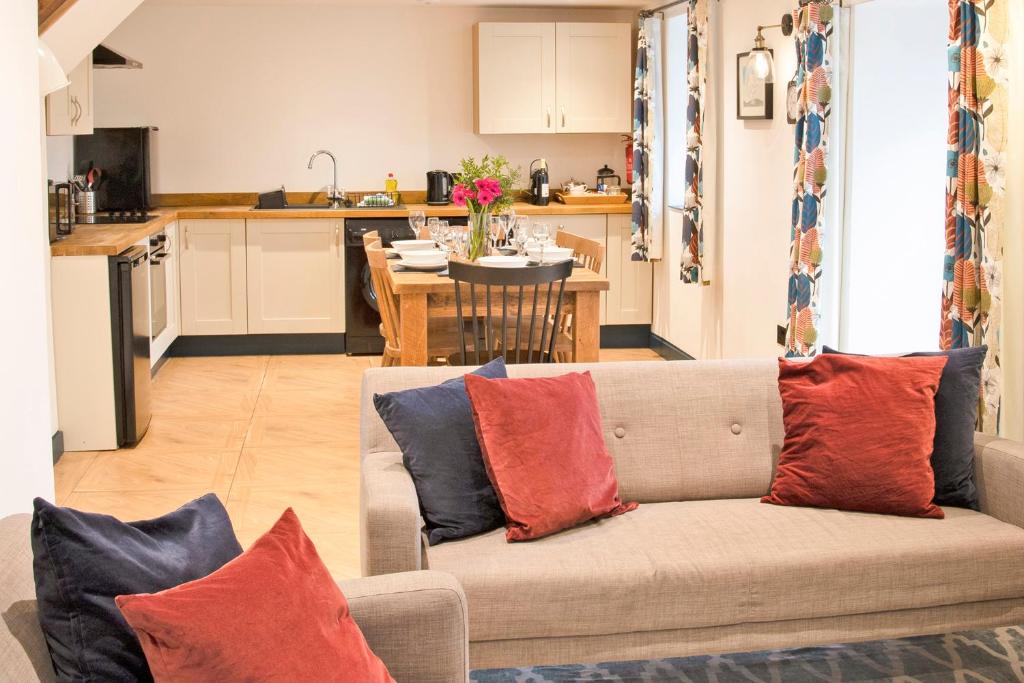 a living room with a couch with red and blue pillows at Stainsborough Hall Holiday Cottages in Wirksworth