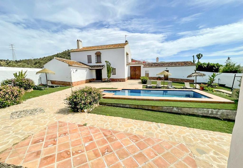 una casa con piscina en el patio en Cortijo Las Caballerias en Alora