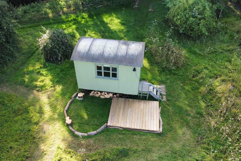 an aerial view of a small house in the grass at The Warren - Cosy Shepherds Hut in beautiful wild meadow in Halesworth