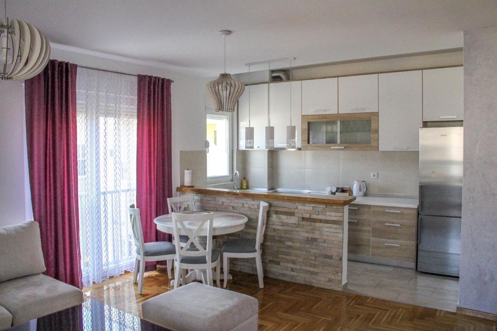 a kitchen with a table and a dining room at Lanai Apartment in Trebinje