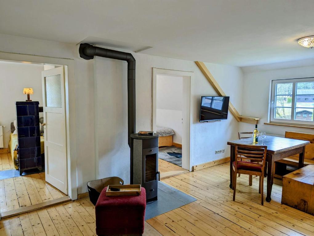 ein Wohnzimmer mit einem Holzofen und einem Tisch in der Unterkunft Landhaus Eilenberg Holzhau in Rechenberg-Bienenmühle