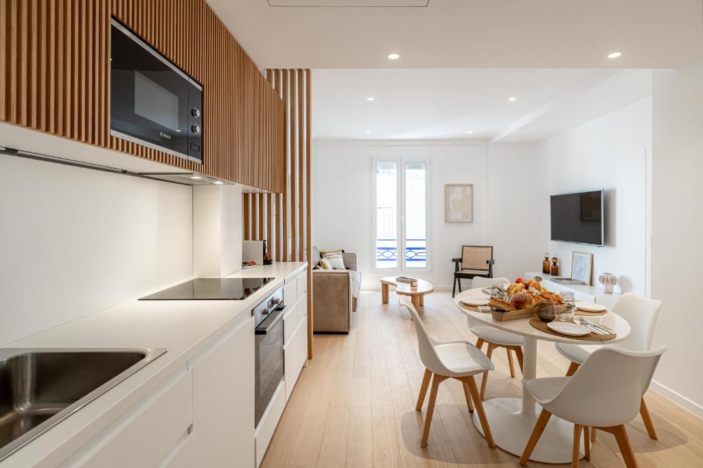 une cuisine et un salon avec une table et des chaises dans l'établissement Two Bedroom Flat steps away from Croisette Cannes, à Cannes