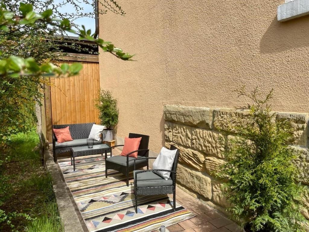 un patio con sillas y una pared de piedra. en Maintal Relax, en Michelau
