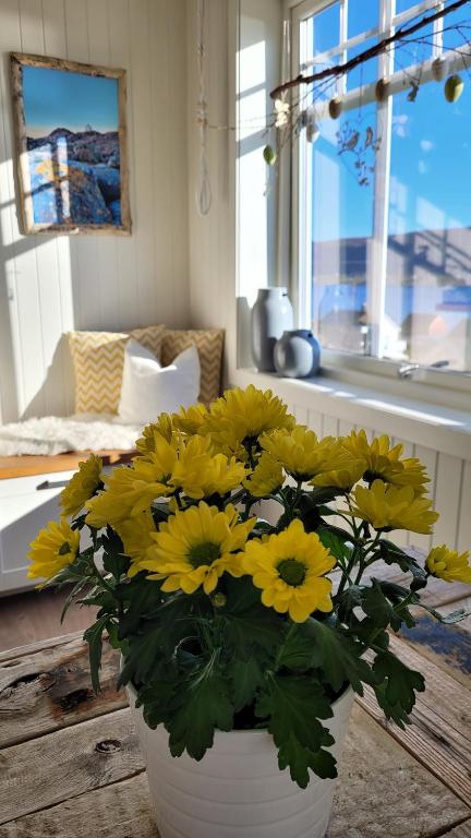 a bouquet of yellow flowers in a white vase at Haramsøy Holiday Apartment- Island Life North in Haram