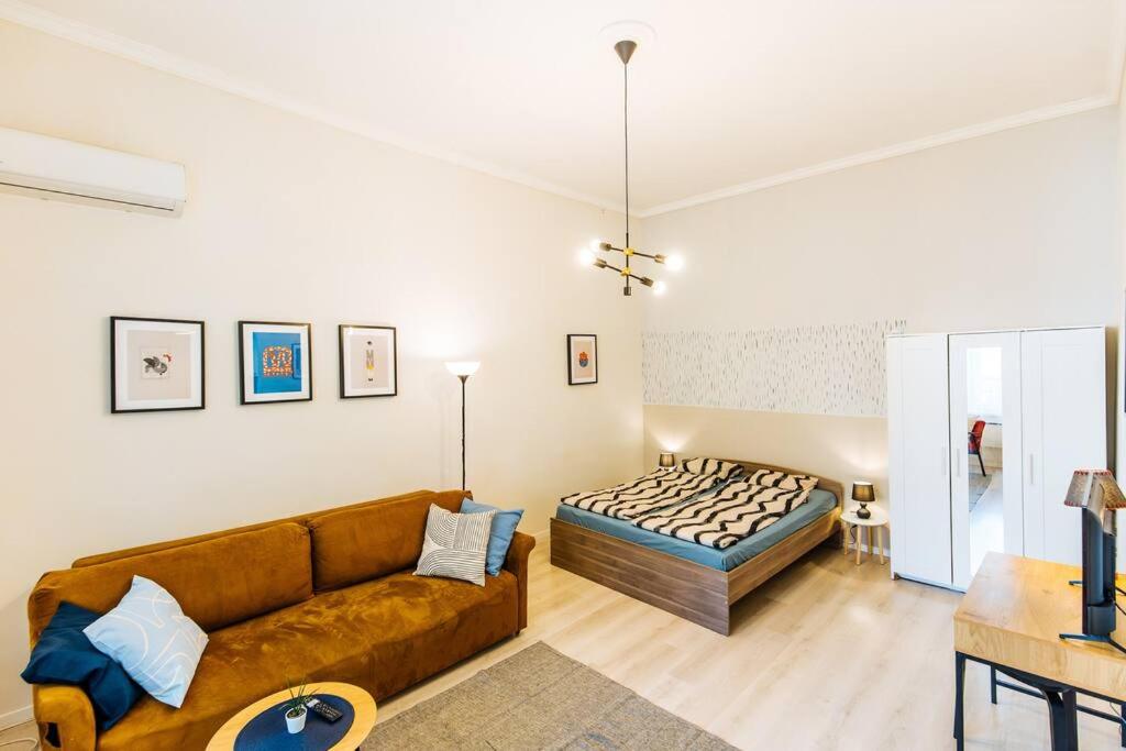 uma sala de estar com um sofá e uma cama em Nature Studio em Budapeste