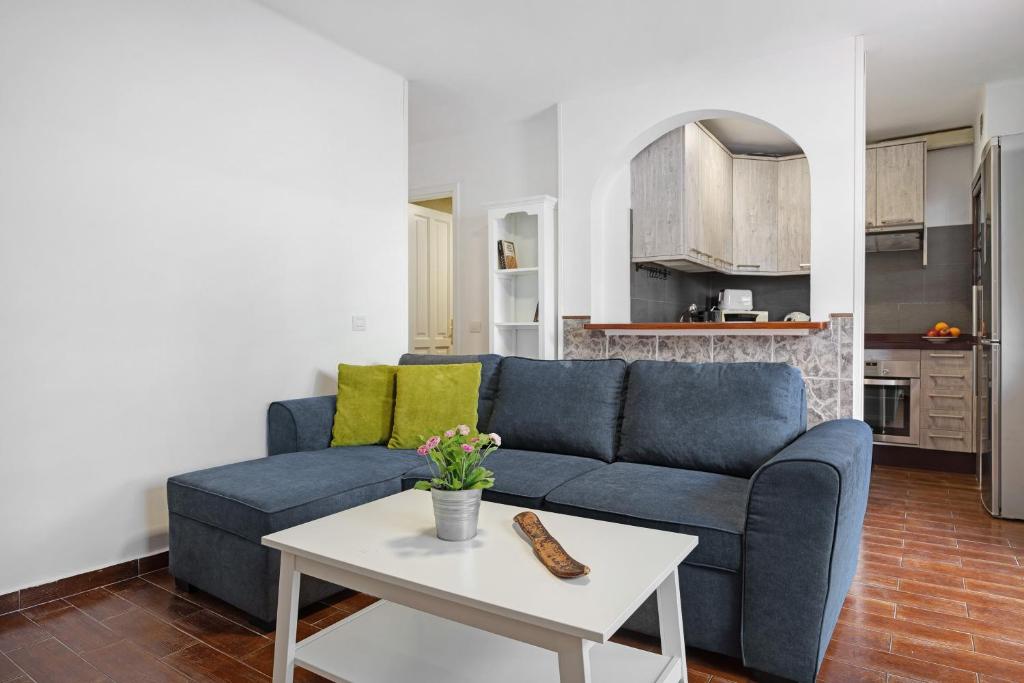 a living room with a blue couch and a table at Apartamento White Sun in Playa Honda