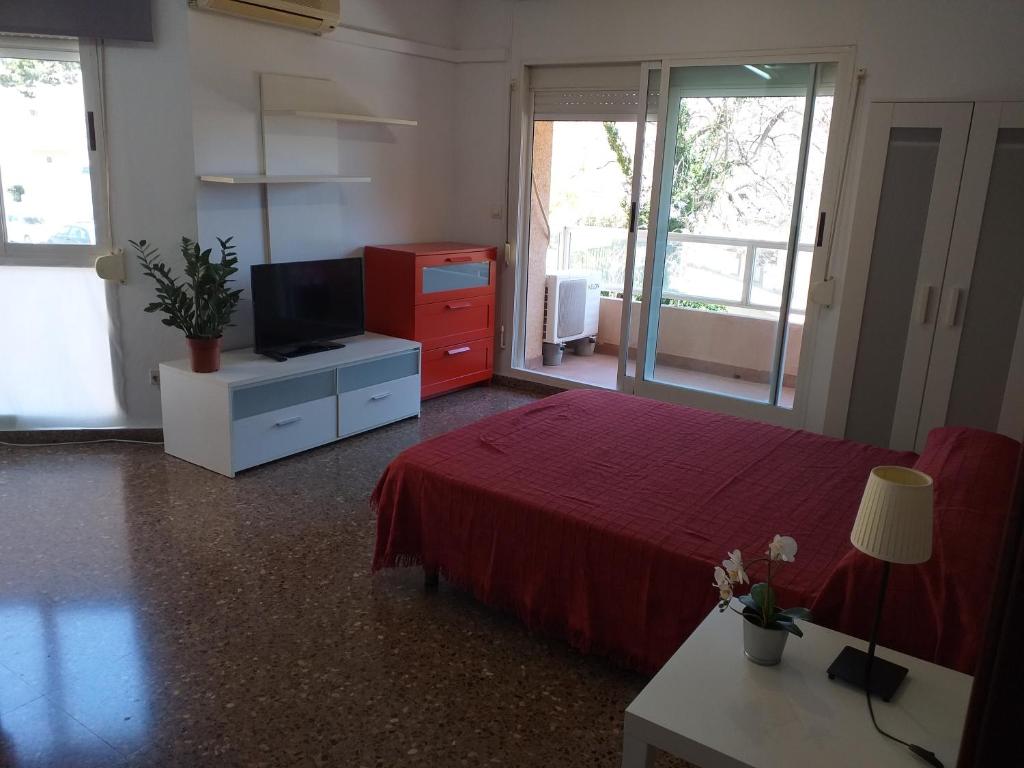 - une chambre avec un lit rouge et une télévision dans l'établissement PISO EN BURJASOT, à Burjasot