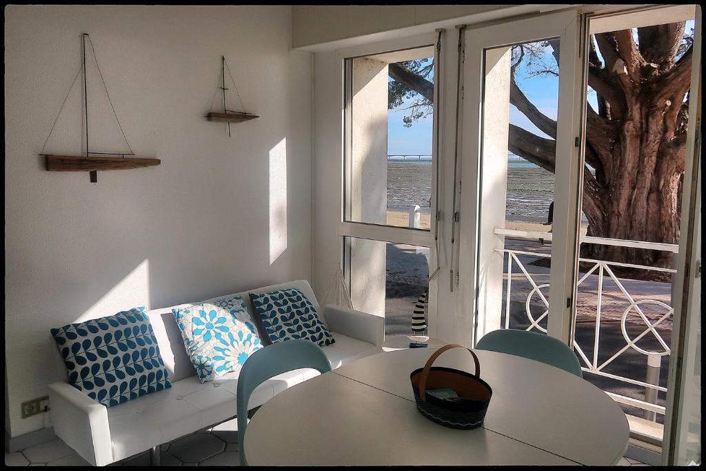 a living room with a couch and a table and a window at Le plongeoir in Saint-Trojan-les-Bains