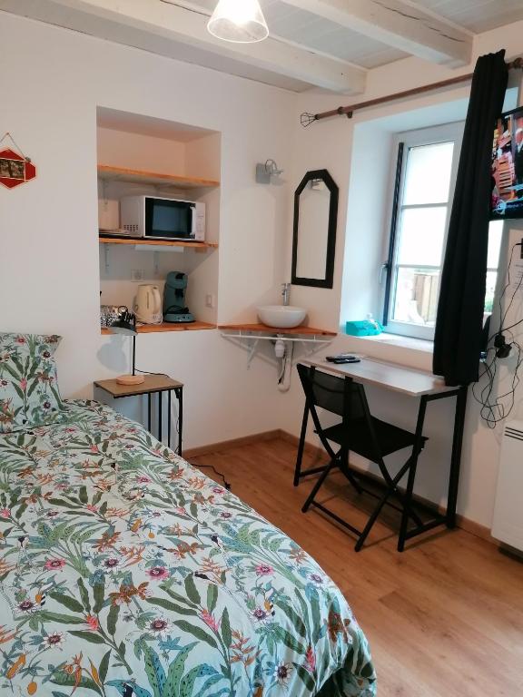 une chambre avec un lit, un bureau et un lavabo dans l'établissement Mini Garni Vendémiaire, à Vesoul