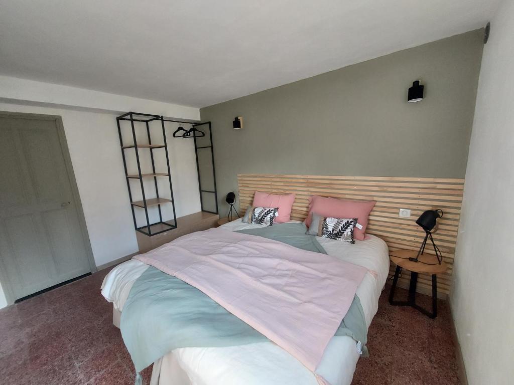 a bedroom with a large bed with pink pillows at Les Pierres de Cézaire in Saint-Cézaire-sur-Siagne