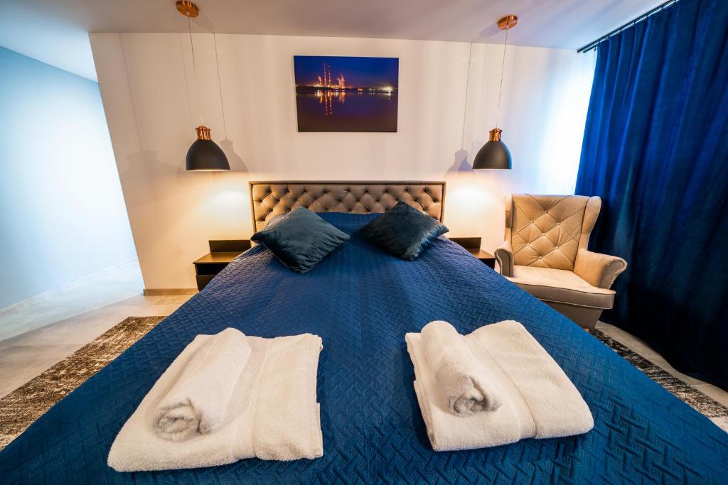 ein Schlafzimmer mit einem blauen Bett und Handtüchern darauf in der Unterkunft Apartament P&B in Rybnik