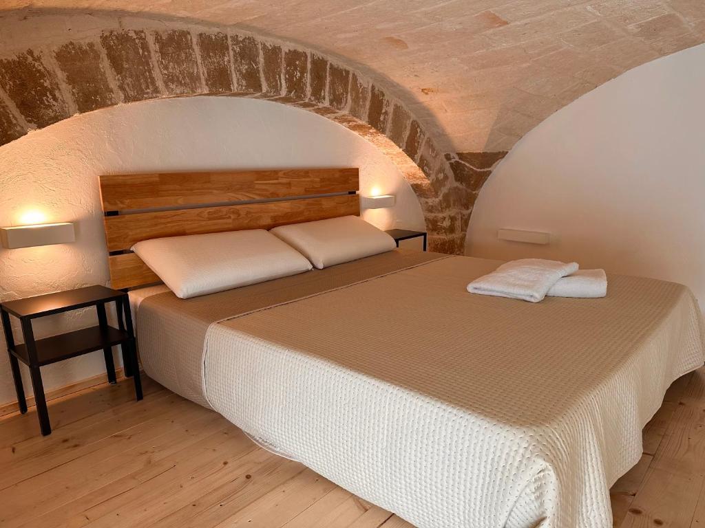 Ce lit se trouve dans une chambre dotée d'un mur en briques. dans l'établissement L'Antica Dimora in Centro, à Bari