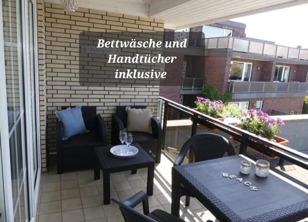 eine Terrasse mit Tisch und Stühlen auf einem Balkon in der Unterkunft Steinmarner Bude in Cuxhaven