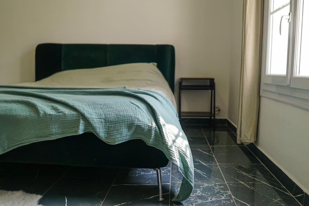 Un dormitorio con una cama con una manta verde. en RIVA BELLA villa plage, en Bandol
