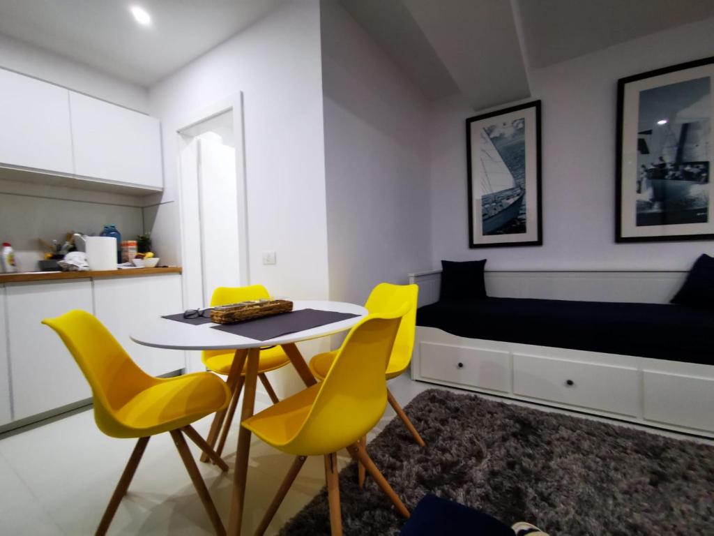 ジュピテルにあるOxygen studioの黄色い椅子、テーブル、ベッドが備わる客室です。