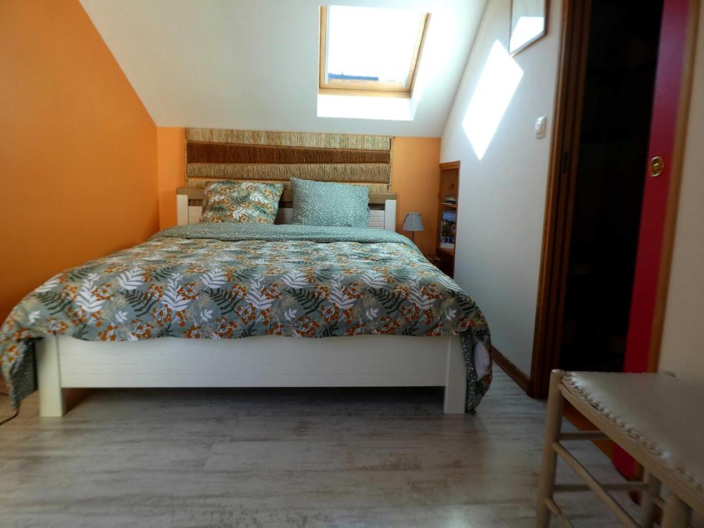 ein Schlafzimmer mit einem Bett im Dachgeschoss in der Unterkunft LA TUILIERE in Mutigny