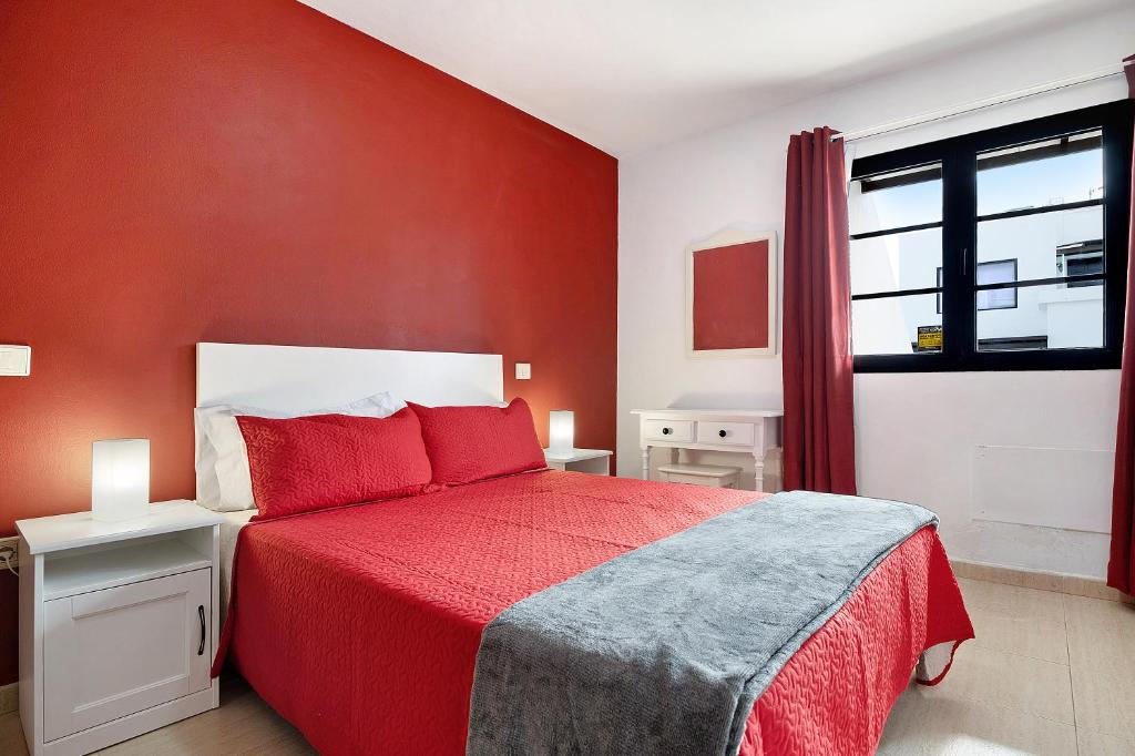 1 dormitorio rojo con 1 cama con pared roja en Casa Candido 2 en Playa Honda