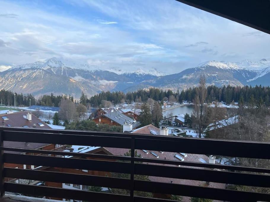 a view of a snowy mountain range from a balcony at Attic Gem with Unbeatable Lake Moubra View in Crans-Montana