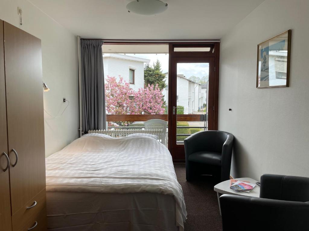 - une chambre avec un lit, une chaise et une fenêtre dans l'établissement Marx Motel, à Fauquemont