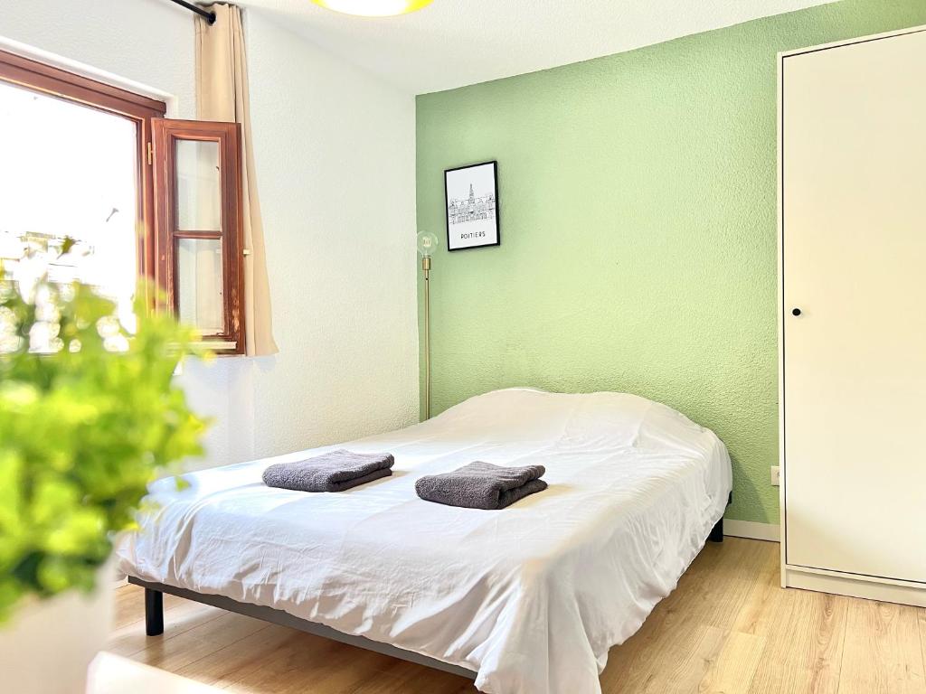 una camera da letto con un letto e due asciugamani di Le OSLO, à 50m de la gare TV connecté+Fibre a Poitiers