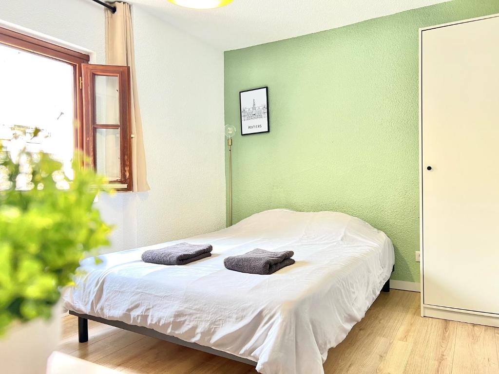 a bedroom with a bed with two towels on it at Le OSLO, à 50m de la gare TV connecté+Fibre in Poitiers